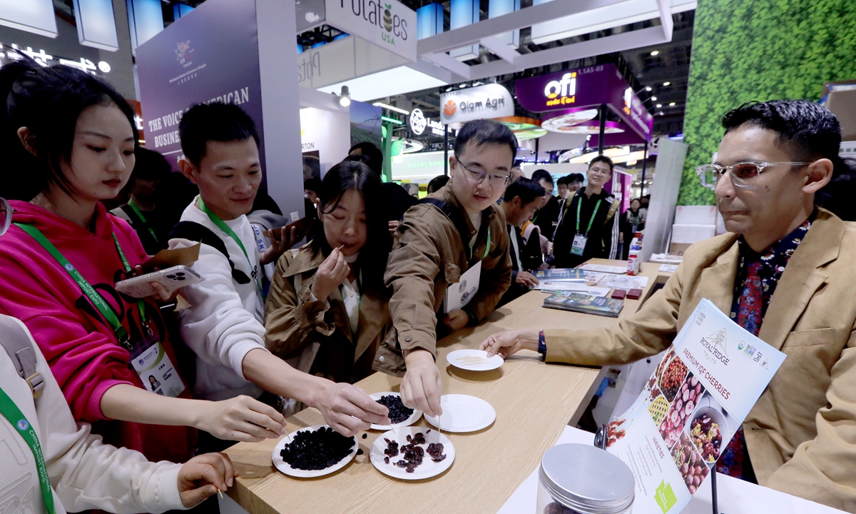 Visitors taste dried cherries at an exhibition booth in the American Food and Agriculture Pavilion at the 7th China International Import Expo on November 8, 2024. The pavilion has an exhibition area of 240 square meters, showcasing various agricultural products from multiple US companies and organizations. Photo: Chen Xia/GT