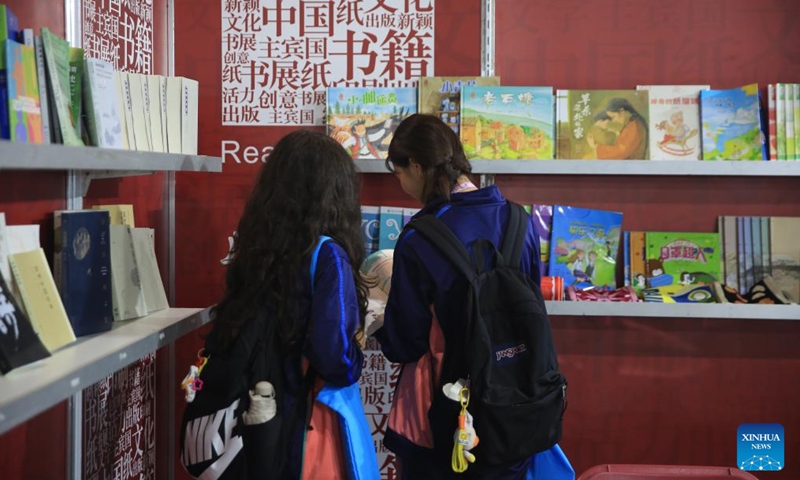 Students read a book at the Chinese exhibition booth during the Malta Book Festival in Ta' Qali, Attard, Malta, on Nov. 8, 2024. A delegation of Chinese publishers, alongside the China Cultural Center in Malta, showcased a variety of Chinese publications at the 45th Malta Book Festival, which runs from Nov. 6 to Nov. 10 in Attard, central Malta. (Photo: Xinhua)