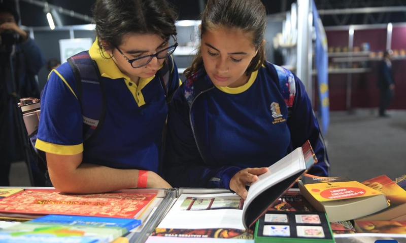 Students read a book at the Chinese exhibition booth during the Malta Book Festival in Ta' Qali, Attard, Malta, on Nov. 8, 2024. A delegation of Chinese publishers, alongside the China Cultural Center in Malta, showcased a variety of Chinese publications at the 45th Malta Book Festival, which runs from Nov. 6 to Nov. 10 in Attard, central Malta. (Photo: Xinhua)