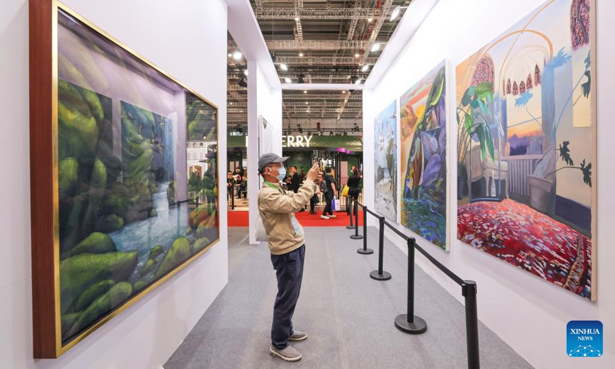 A visitor takes photo at the Antiques and Fine Art exhibition area during the 7th China International Import Expo (CIIE) in east China's Shanghai, Nov. 7, 2024. The Antiques and Fine Art exhibition area has been set up for four consecutive years at CIIE.    (Photo: Xinhua)