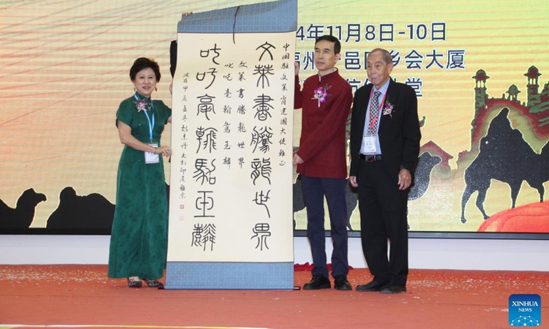 Chinese Ambassador to Brunei Xiao Jianguo (C) and other participants display a piece of Chinese calligraphy work at the fifth International Chinese Calligraphy Grand Exhibition in Bandar Seri Begawan, capital of Brunei, Nov. 8, 2024. The fifth International Chinese Calligraphy Grand Exhibition opened in Brunei on Friday, featuring over 300 Chinese calligraphy works by artists from around the world.(Photo: Xinhua)