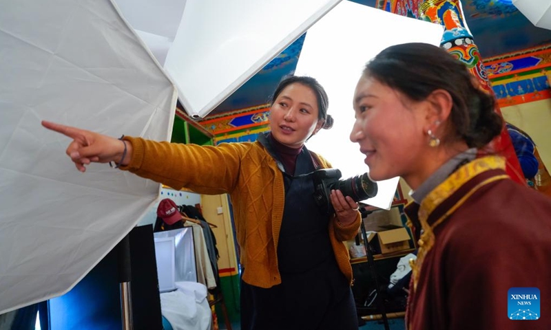 Dawa Drolma (L) instructs a model on how to pose for photos with earrings at her workshop in Maisu Town of Dege County in Garze Tibetan Autonomous Prefecture, southwest China's Sichuan Province, Nov. 4, 2024. (Photo: Xinhua)