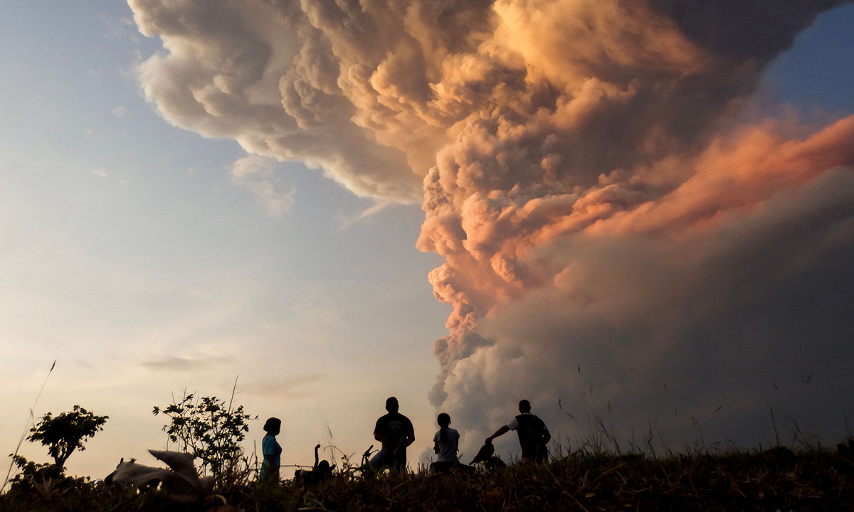 Residents watch the eruption of Mount Lewotobi Laki Laki from Lewolaga village in East Nusa Tenggara, Indonesia, on November 9, 2024, as the volcano spews towering columns of hot ash high into the air. Volcanic activity saw the largest column of ash so far recorded at 10 kilometers high on November 8. Photo: VCG