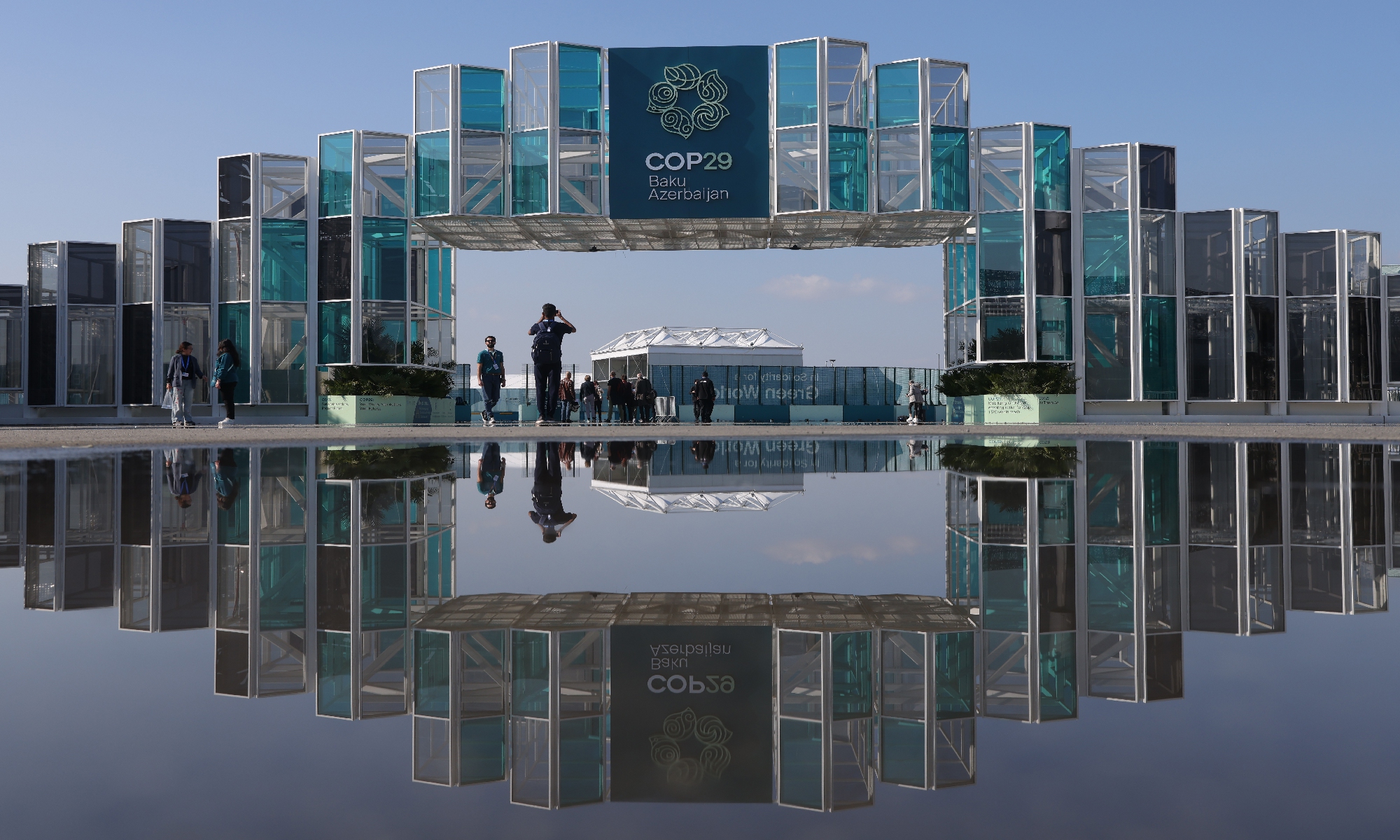 People stand outside the conference venue prior to the COP29 Climate Conference on November 10, 2024 in Baku, Azerbaijan. COP29, which is running from November 11 to 22, is bringing together government leaders, scientists, environmentalists, industries and others to discuss and agree on the implementation of global measures toward mitigating the effects of climate change. Photo: VCG