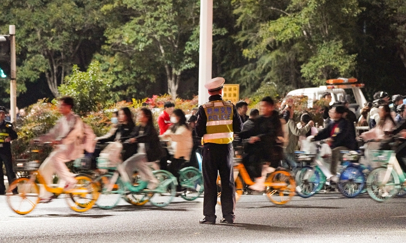 A traffic officer manages traffic on Zhengkai Avenue, linking Zhengzhou and Kaifeng in Central China’s Henan Province, where temporary controls were put in place on November 9, 2024, to ensure the safety of college students taking part in a night cycling event. Photo: CFP