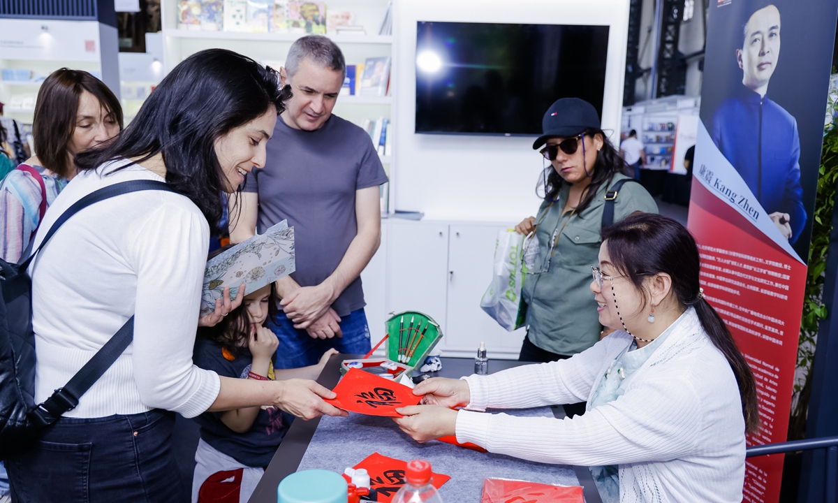 A guest receives a calligraphy work featuring the Chinese character 