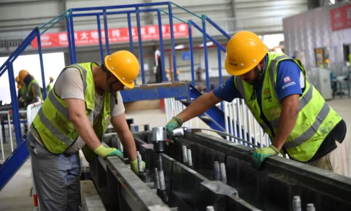 A new Chinese railway sleeper factory commenced operations on November 10 in Tindouf, a province in western Algeria, marking the full launch of China Railway Construction Corporation's Western Algeria Railway Mining Line project. Pictured are two Algerian workers operating on the light rail production line.  Photo: China Railway Construction Corporation