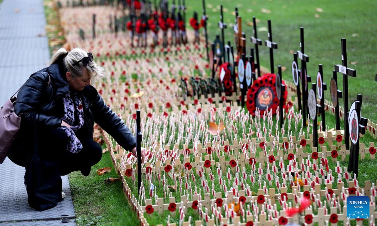 A woman arranges poppy petals and crosses at the Field of Remembrance at Westminster Abbey on the occasion of Remembrance Day in London, Britain, on Nov. 11, 2024. Remembrance Day is observed to remember the sacrifices made by soldiers during the WWI, which ended on Nov. 11, 1918. (Photo: Xinhua)