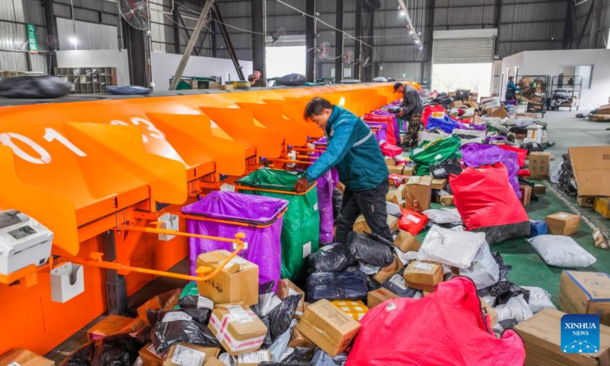 A drone photo shows staff members sorting packages at a logistic center of Zunhua branch of China Post in Zunhua City, north China's Hebei Province, Nov. 11, 2024. Manufacturers, e-commerce platforms and logistics companies across the country are busy coping with customer's demand during China's annual Double 11 shopping festival.   (Photo: Xinhua)