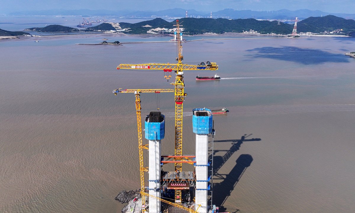 Workers install cross-beam steel for the Shuangyumen bridge in Zhoushan, East China's Zhejiang Province, on November 12, 2024. The main span of the Shuangyumen bridge is 1,768 meters, making it the world's longest single-span, single-tower suspension bridge with a steel box girder, as well as the bridge with the longest span across the sea in China. Photo: VCG