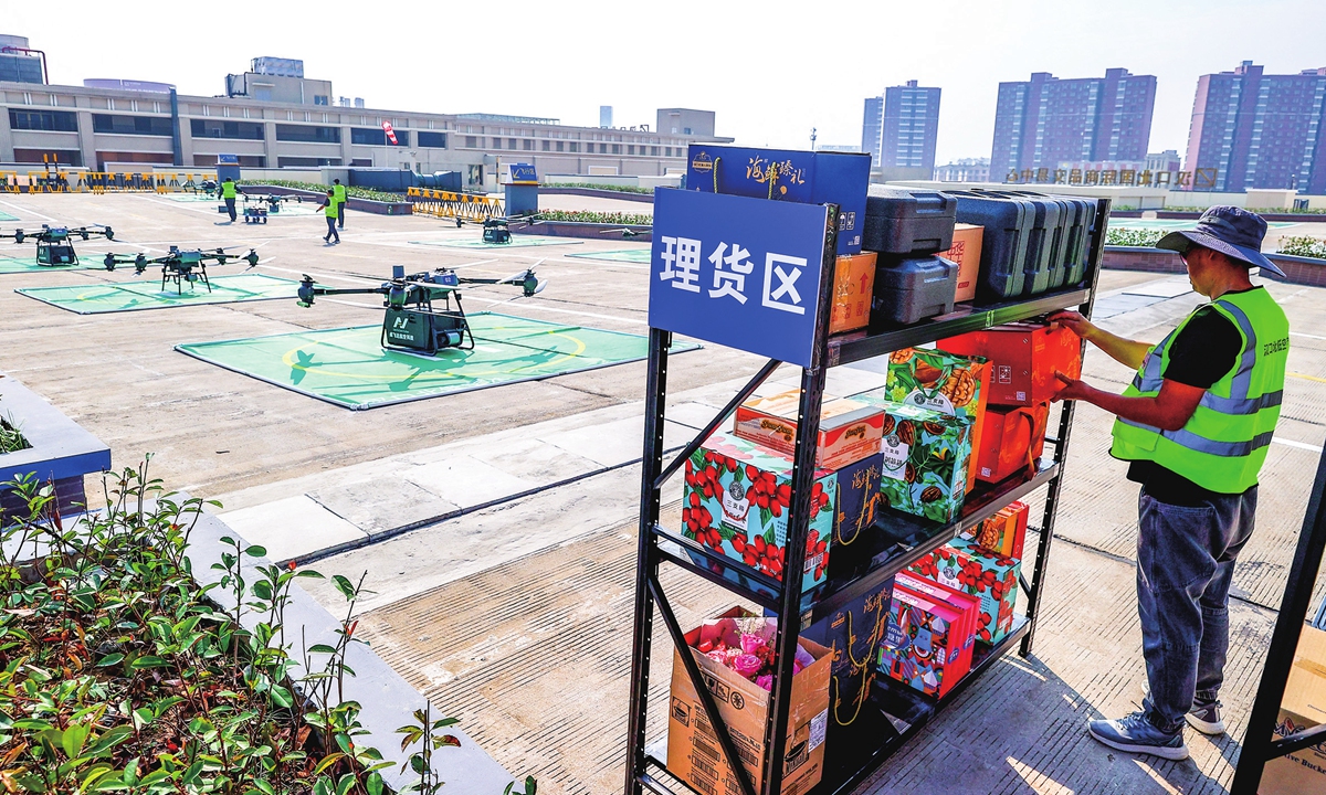 A staff member sorts packages as unmanned aerial vehicles prepare to transport shipments of seafood, flowers and apparel to destinations at the end of five low-altitude flight routes in Wuhan, Central China's Hubei Province on November 12, 2024. The country's first low-altitude logistics operation base inside a commodity market was inaugurated on the same day. Photo: cnsphoto 