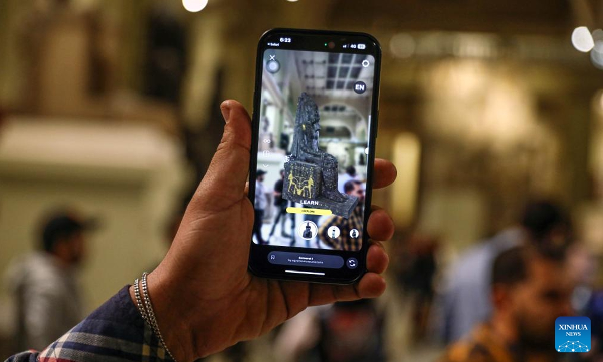 A person views an artifact through a cell phone with a new digital filter application to reconstruct damaged ancient Egyptian artifacts at the Egyptian Museum in Cairo, Egypt, on Nov. 11, 2024.  (Photo: Xinhua)