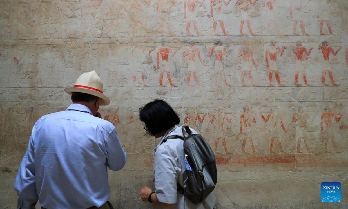 Tourists view colored relief paintings inside the tomb of a an official of ancient Egypt in Saqqara necropolis, south of Cairo, Egypt, Nov. 12, 2024. The Saqqara necropolis is home to numbers of noble tombs, in which many colored relief paintings depicting ancient Egyptian daily life are still well preserved.  (Photo: Xinhua)