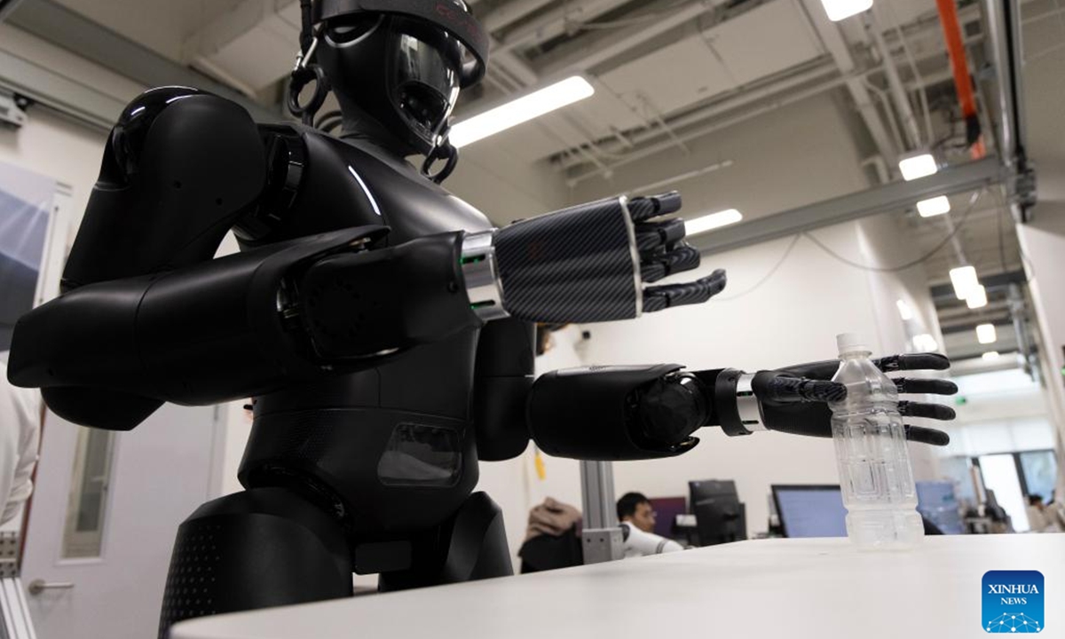 Researchers adjust CASBOT 01 at a laboratory in Beijing, capital of China, Nov. 12, 2024. The humanoid robot CASBOT 01 was released through livestream to the public in Beijing on Wednesday evening. The robot, nicknamed Wednesday, has a height of 1.79 meters and a weight of 60 kilograms, and can work continuously for four hours.  (Photo: Xinhua)