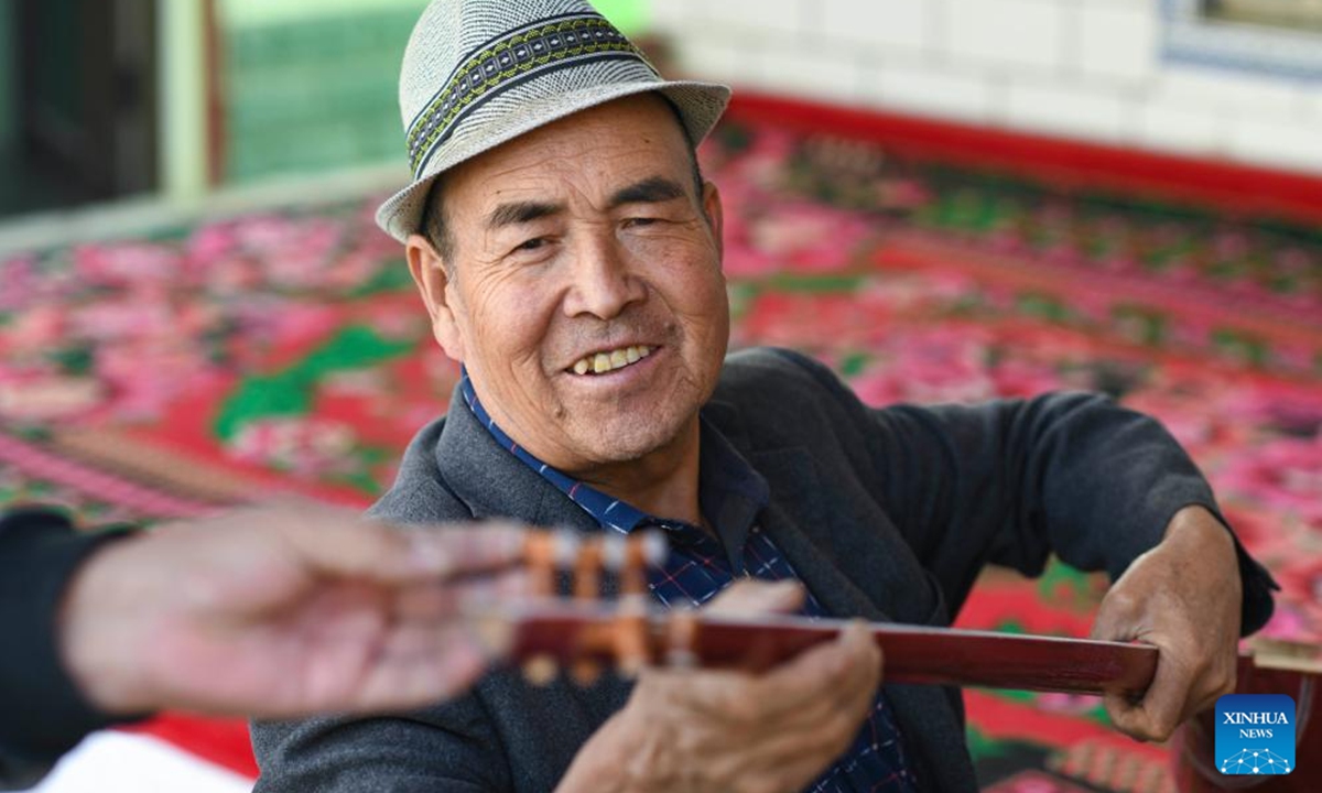 Nurdun Esmayil installs strings for a folk musical instrument with his friend at home in Xinhe County, northwest China's Xinjiang Uygur Autonomous Region, Oct. 29, 2024.   (Photo: Xinhua)