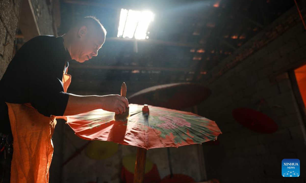 Zheng Guomin, a provincial-level inheritor of intangible cultural heritage, makes oilcloth umbrella at Guomin Oilcloth Umbrella Plant in Gufeng Village of Jingxian County, east China's Anhui Province, Nov. 13, 2024. The umbrella, made of oiled cloth and bamboo frame, is a traditional Chinese handicraft.  (Photo: Xinhua)