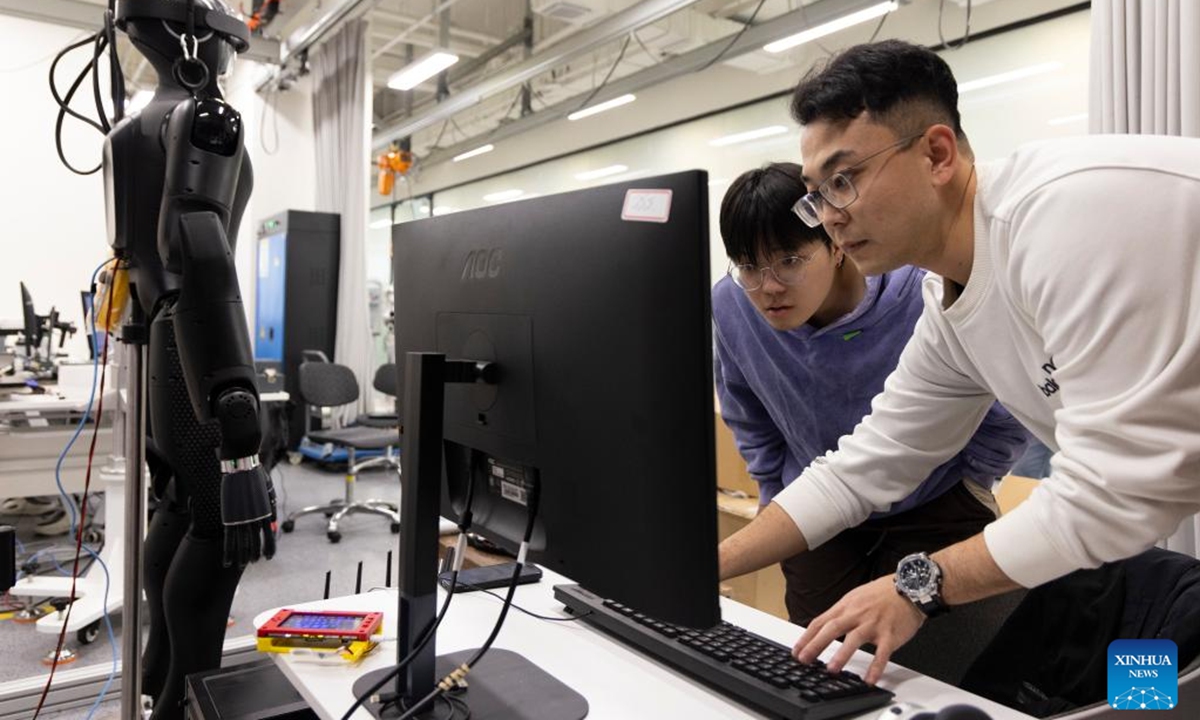 Researchers adjust CASBOT 01 at a laboratory in Beijing, capital of China, Nov. 12, 2024. The humanoid robot CASBOT 01 was released through livestream to the public in Beijing on Wednesday evening. The robot, nicknamed Wednesday, has a height of 1.79 meters and a weight of 60 kilograms, and can work continuously for four hours.  (Photo: Xinhua)