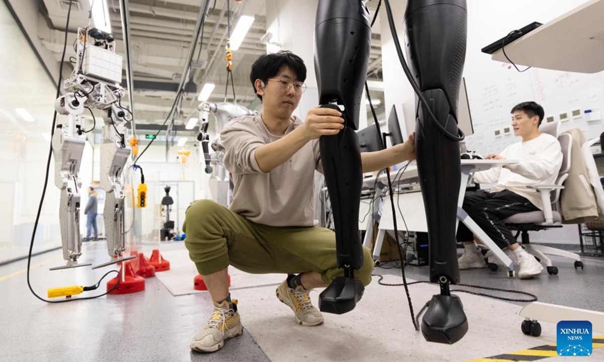 Researchers adjust CASBOT 01 at a laboratory in Beijing, capital of China, Nov. 12, 2024. The humanoid robot CASBOT 01 was released through livestream to the public in Beijing on Wednesday evening. The robot, nicknamed Wednesday, has a height of 1.79 meters and a weight of 60 kilograms, and can work continuously for four hours.  (Photo: Xinhua)