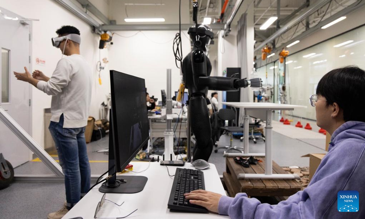 Researchers adjust CASBOT 01 at a laboratory in Beijing, capital of China, Nov. 12, 2024. The humanoid robot CASBOT 01 was released through livestream to the public in Beijing on Wednesday evening. The robot, nicknamed Wednesday, has a height of 1.79 meters and a weight of 60 kilograms, and can work continuously for four hours.  (Photo: Xinhua)