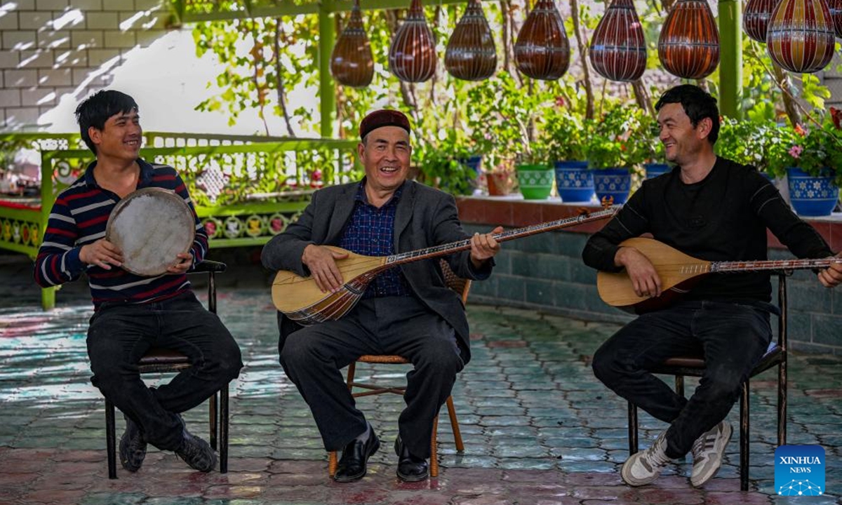 Nurdun Esmayil (C) plays music with his son, Ehmet Nurdun (L), and his apprentice in his courtyard in Xinhe County, northwest China's Xinjiang Uygur Autonomous Region, Oct. 15, 2024.   (Photo: Xinhua)