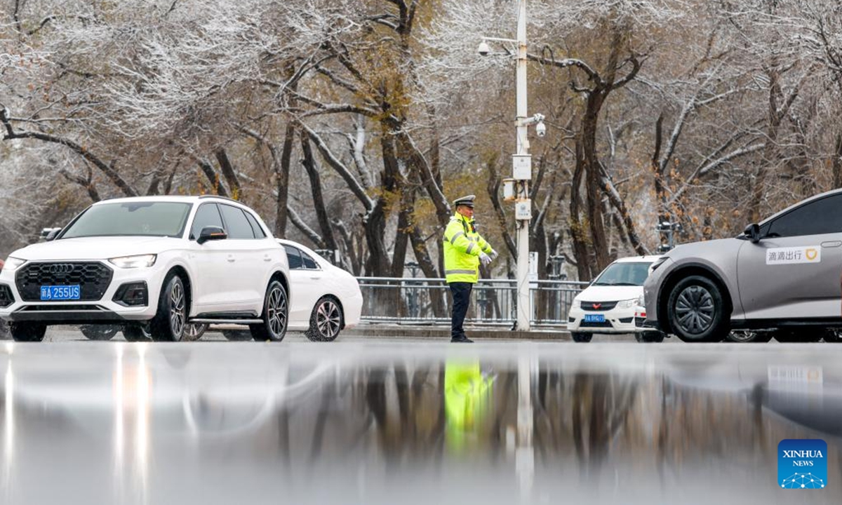 A traffic police officer is on duty in Urumqi, northwest China's Xinjiang Uygur Autonomous Region, Nov. 14, 2024. A cold front has ushered in significant drop in temperature and snowfall across Xinjiang. (Photo: Xinhua)