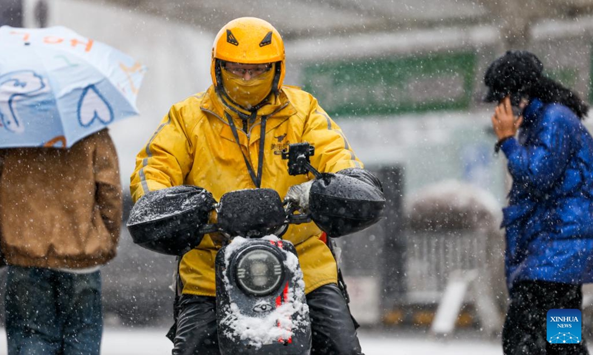 People walk in snow in Urumqi, northwest China's Xinjiang Uygur Autonomous Region, Nov. 14, 2024. A cold front has ushered in significant drop in temperature and snowfall across Xinjiang. (Photo: Xinhua)