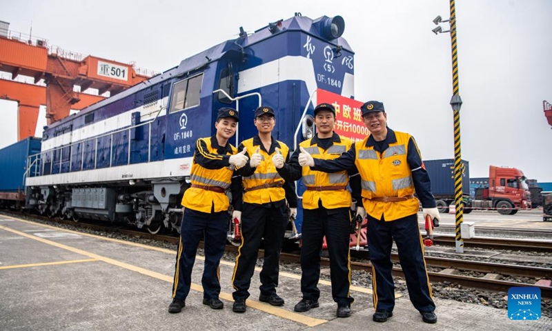 Staff members pose for a photo in front of the 100,000th China-Europe freight train, coded X8083, at the Tuanjiecun Station in Chongqing, southwest China, Nov. 15, 2024. (Photo: Xinhua)