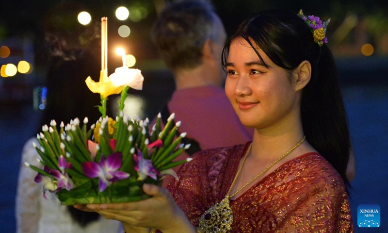 A woman prepares to release a water lantern during the Loy Krathong Festival by the Chao Phraya River in Ayutthaya, Thailand, Nov. 15, 2024. (Photo: Xinhua)