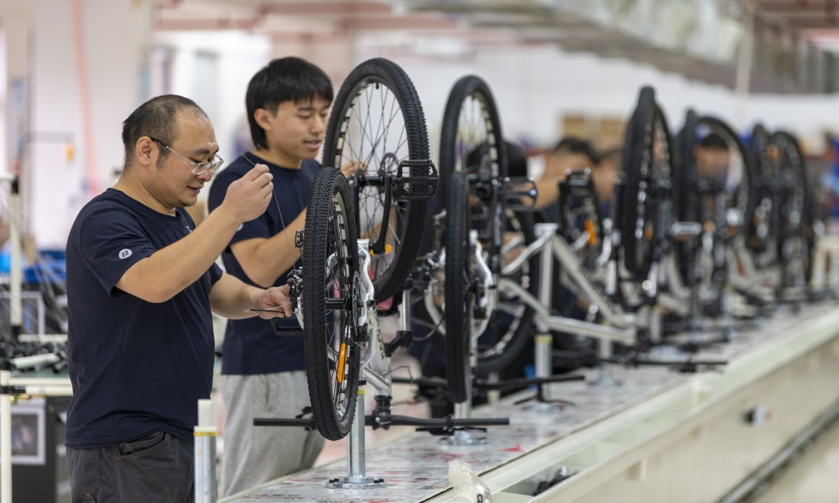 
Workers at a sporting goods company in Yiwu, East China’s Zhejiang Province assemble mountain bikes bound for overseas markets in the production line, on November 15, 2024, gearing up for the Christmas and Black Friday shopping sprees around the world. 