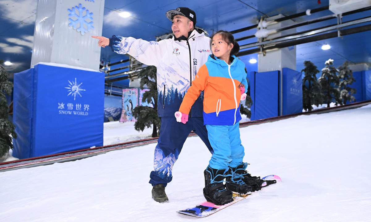 A girl learns snowboarding under the guidance of a coach in Shenyang, Northeast China's Liaoning Province, on November 16, 2024. Photo: VCG