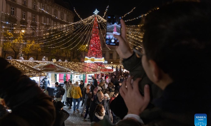 A man takes photos of a Christmas market in downtown Budapest, Hungary on Nov. 15, 2024. (Photo by Attila Volgyi/Xinhua)