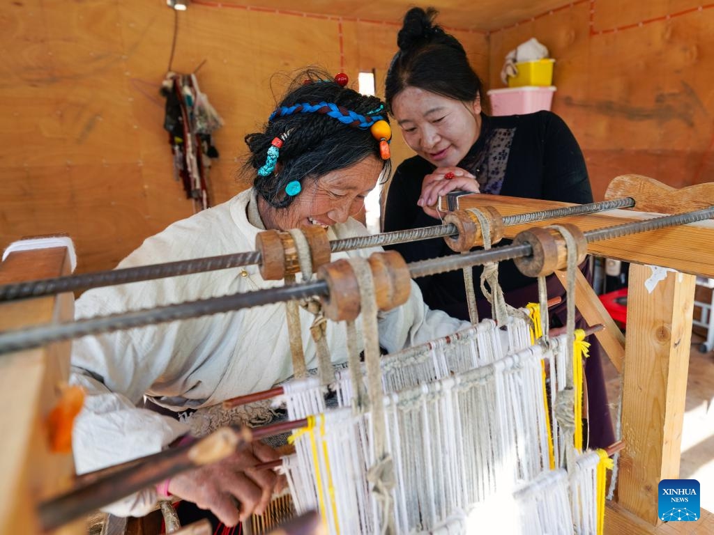 Doltru (L) demonstrates weaving skill for an apprentice at her workshop in Dege County of Garze Tibetan Autonomous Prefecture, southwest China's Sichuan Province, Nov. 3, 2024.(Xinhua/Shen Bohan)