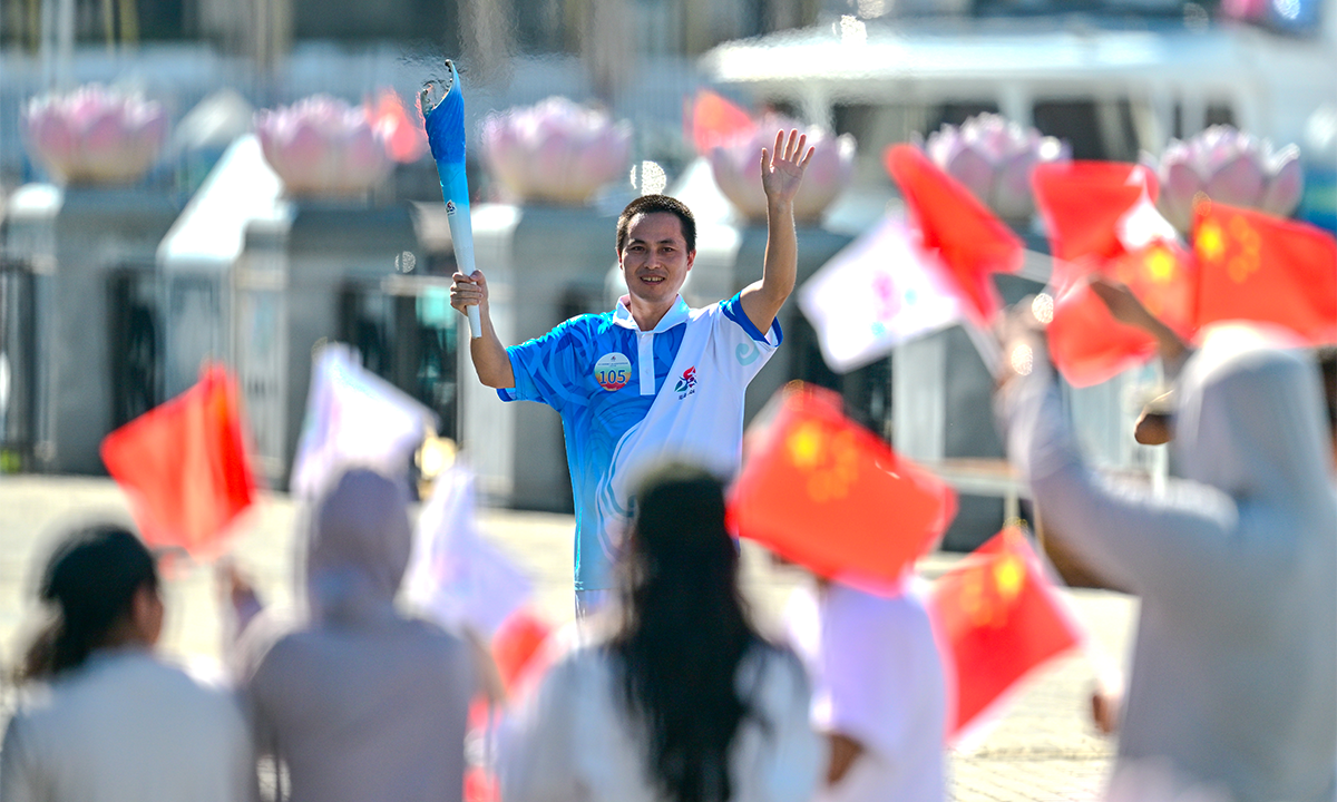 A torch bearer participates in the torch relay for the 12th National Traditional Games of Ethnic Minorities of the People’s Republic of China on November 17, 2024 in Sanya, Hainan Province. The relay included 107 torchbearers from various walks of life. Photo: VCG