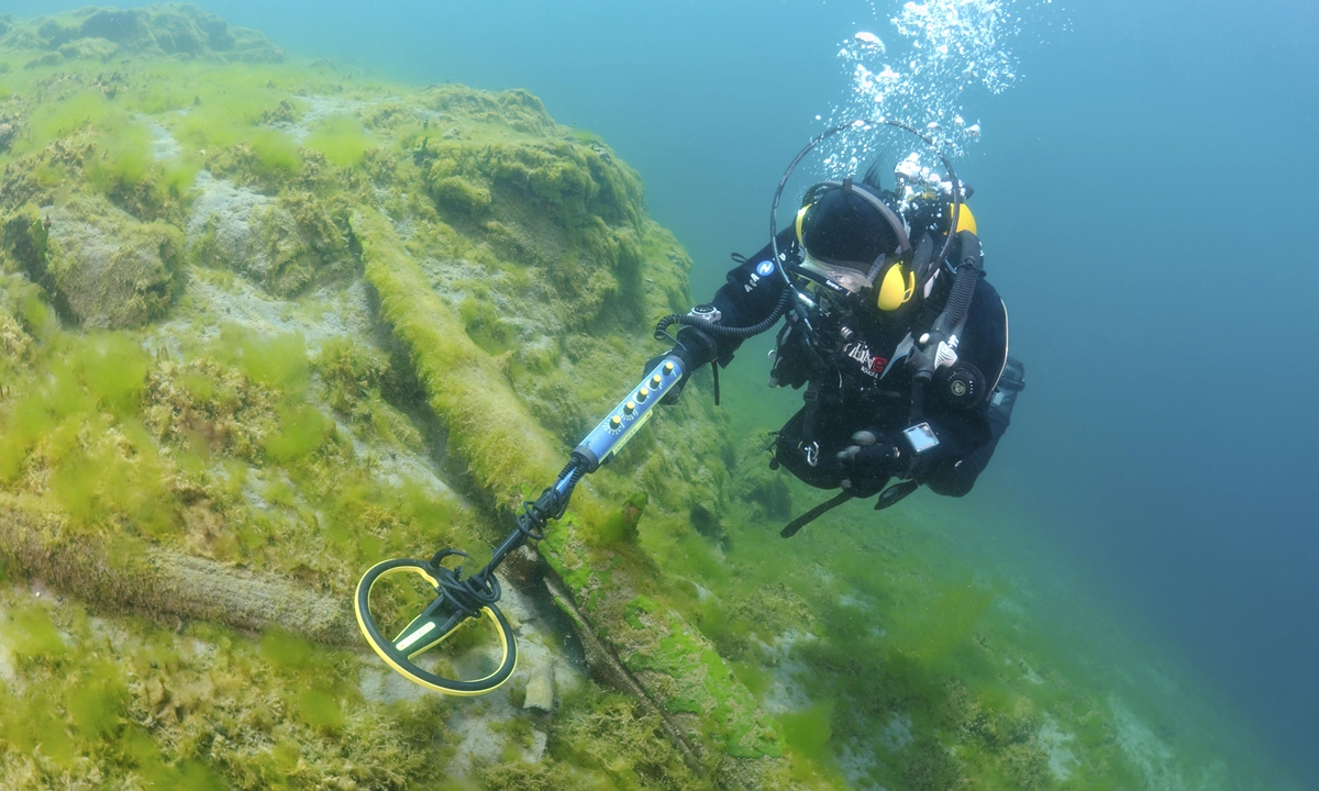 A diver searches for underwater relics with a detector. Photo: VCG