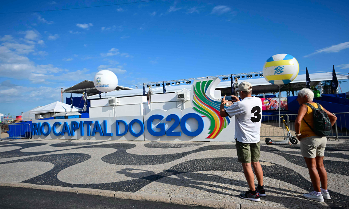 Beachgoers take pictures of a G20 Summit banner at Copacabana beach, Rio de Janeiro, Brazil, on November 6, 2024. Photo: VCG