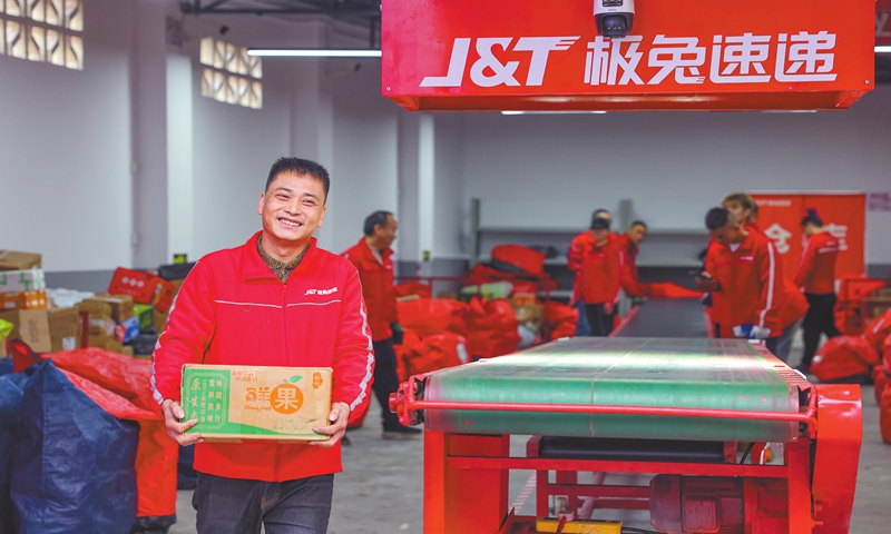 A courier from J&T Express holds a box of apples and prepares to deliver the package at a branch in Southwest China's Chongqing Municipality on November 19, 2024. The box marks China's 150 billionth logistics package so far this year. The State Post Bureau announced on Monday that the express delivery volume in 2024 surpassed that mark for the first time. Photo: VCG