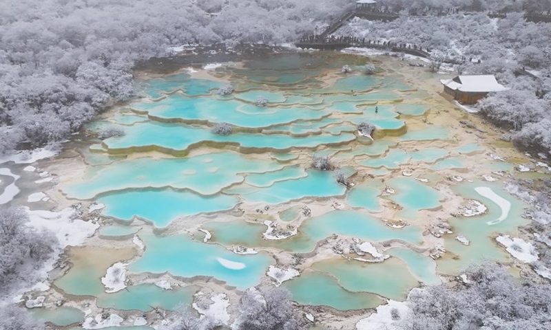 An aerial drone photo taken on Nov. 18, 2024 shows a view of a colorful pond cluster at Huanglong scenic area after snow in Tibetan-Qiang Autonomous Prefecture, southwest China's Sichuan Province.(Photo: Xinhua)