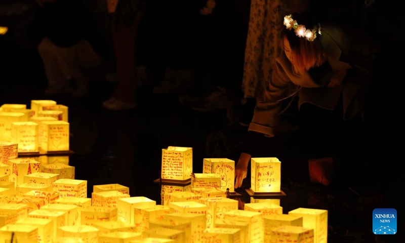 A girl sets afloat a water lantern during a water lantern festival in South El Monte, Los Angeles, California, the United States, on Nov. 17, 2024. (Photo: Xinhua)