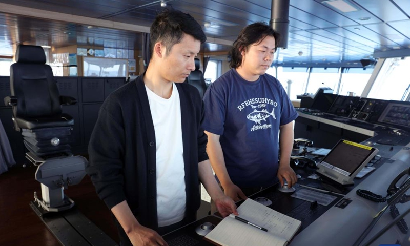 First mate Zhu Pengtao (L) and sailor Chen Dongbin adjust the navigation course aboard China's research icebreaker Xuelong 2. Currently on China's 41st Antarctic expedition, research icebreakers Xuelong and Xuelong 2, or Snow Dragon and Snow Dragon 2, will begin to plough through the belt of prevailing westerlies, nicknamed the rolling forties, on Tuesday. (Photo: Xinhua)