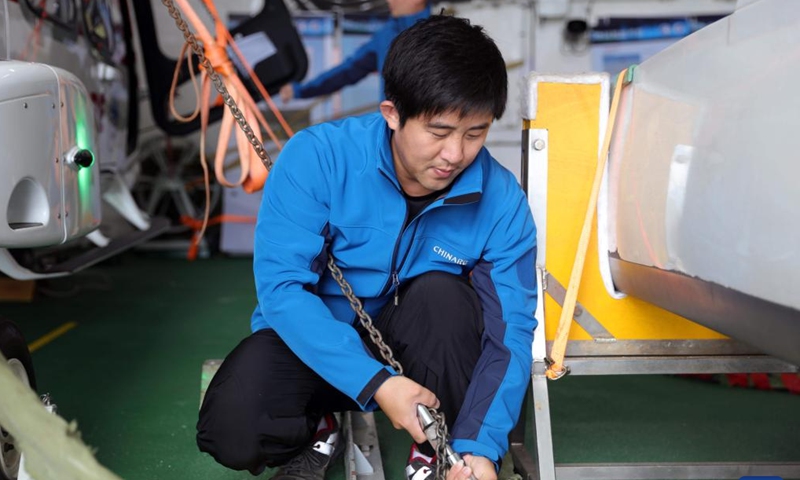 Helicopter crew member Bi Lingfeng works aboard China's research icebreaker Xuelong 2. Currently on China's 41st Antarctic expedition, research icebreakers Xuelong and Xuelong 2, or Snow Dragon and Snow Dragon 2, will begin to plough through the belt of prevailing westerlies, nicknamed the rolling forties, on Tuesday. (Photo: Xinhua)