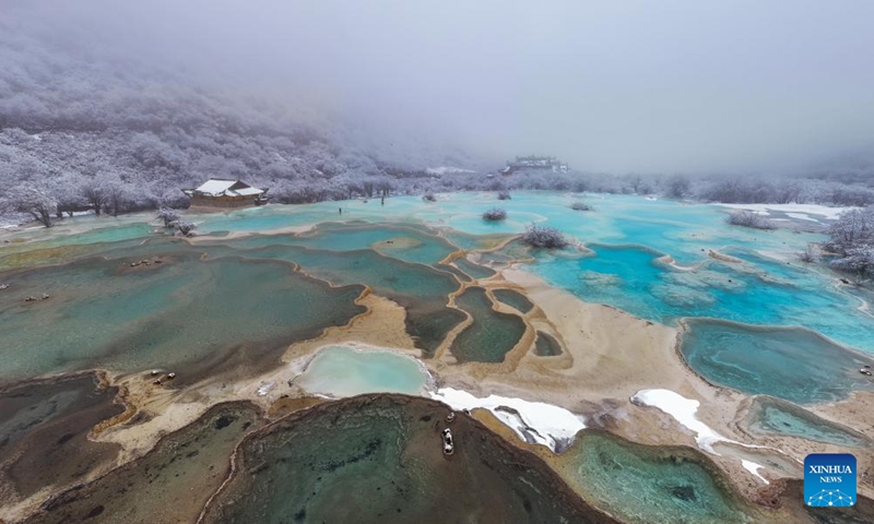 An aerial drone photo taken on Nov. 18, 2024 shows a view of a colorful pond cluster at Huanglong scenic area after snow in Tibetan-Qiang Autonomous Prefecture, southwest China's Sichuan Province. (Photo: Xinhua)