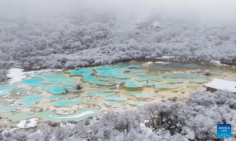 An aerial drone photo taken on Nov. 18, 2024 shows a view of a colorful pond cluster at Huanglong scenic area after snow in Tibetan-Qiang Autonomous Prefecture, southwest China's Sichuan Province. (Photo: Xinhua)