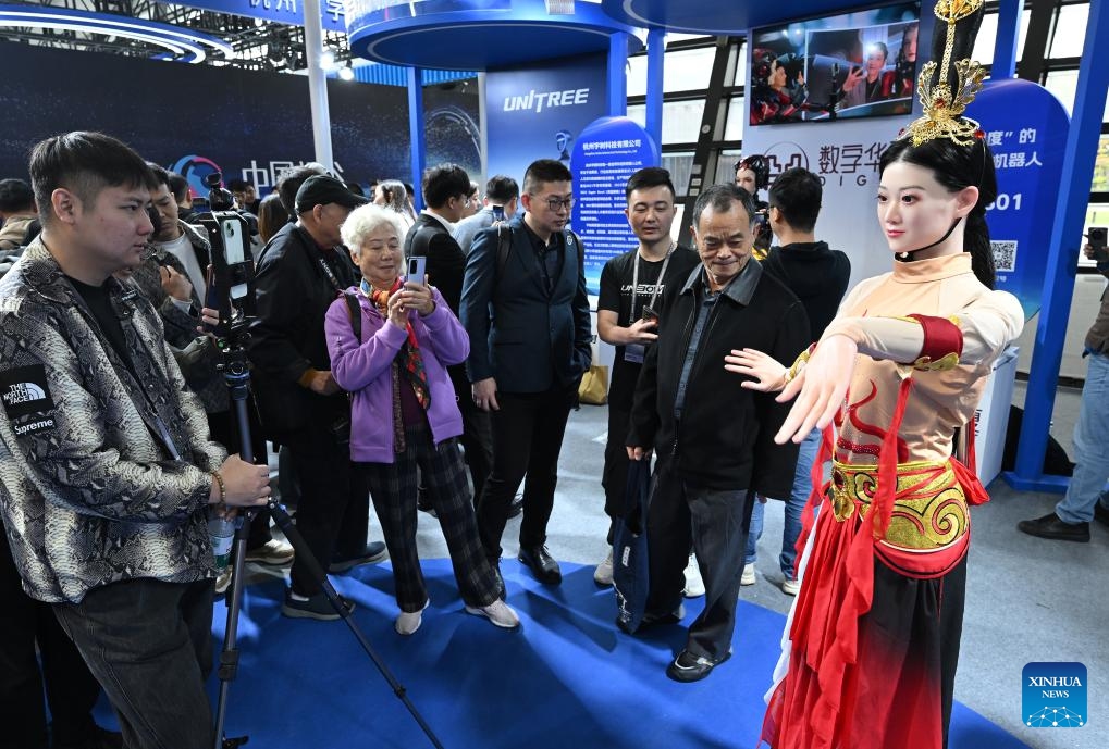 A humanoid robot (1st R) interacts with visitors at the Light of Internet Expo in Wuzhen, east China's Zhejiang Province, Nov. 19, 2024. The Light of Internet Expo kicked off on Tuesday during the 2024 World Internet Conference (WIC) Wuzhen Summit in the water-town of Wuzhen, showcasing the latest technological achievements, especially those made in the artificial intelligence (AI) area. (Photo: Xinhua)