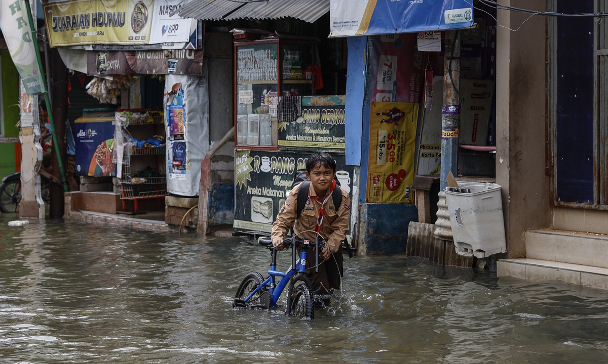 

A child pushes his bicycle through high tide flood water on a street in Jakarta, Indonesia, on November 20, 2024. Indonesia's Meteorology, Climatology, and Geophysical Agency has released an early warning for possible high tide floods in Jakarta's coastal area on November 14 to 21. Photo: IC