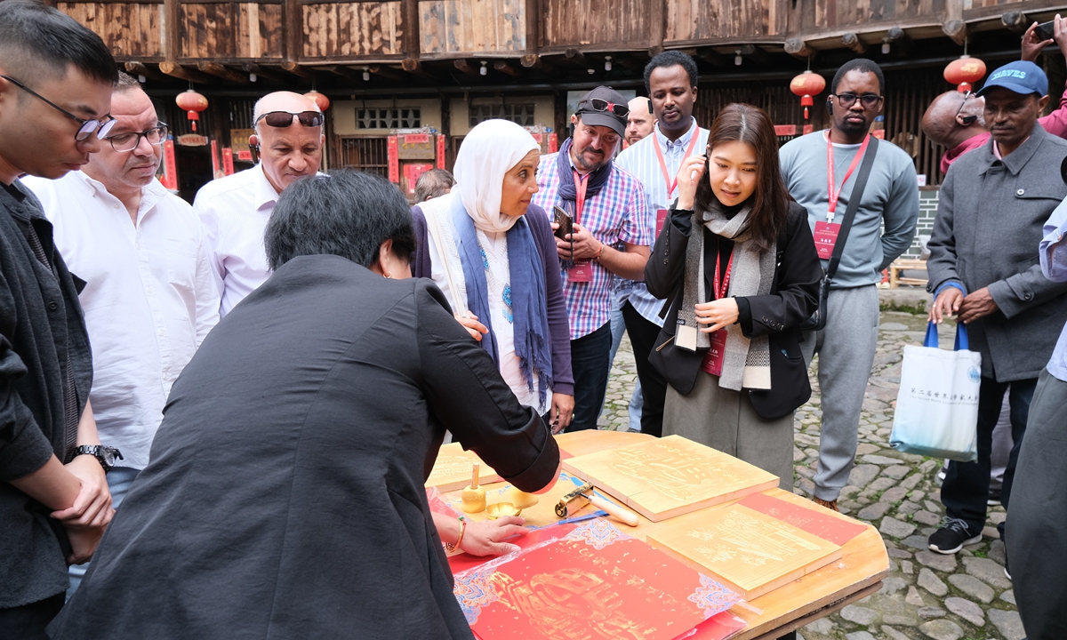 Visitors gather at an ink rubbing workshop where they can make a print of the tulou in Zhangzhou on October 29, 2024. Photo: Bi Mengying/GT