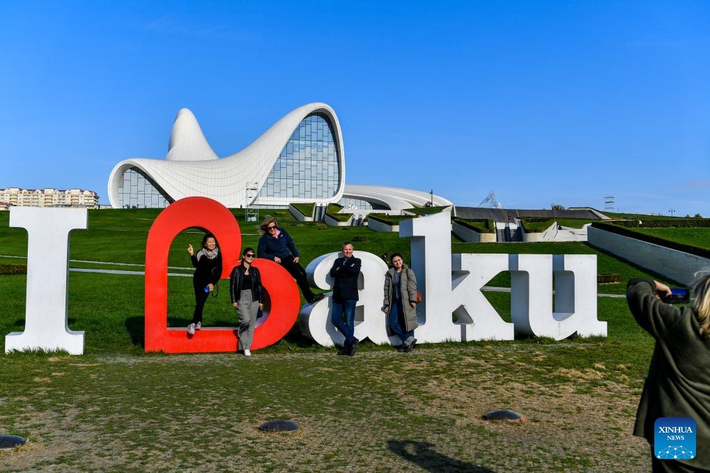 People pose for photos outside the Heydar Aliyev Center in Baku, capital of Azerbaijan, Nov. 15, 2024. (Photo: Xinhua)