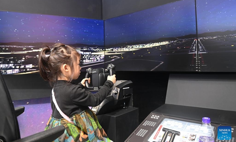 A child tries her hands on a digital flight simulator at the Light of Internet Expo in Wuzhen, east China's Zhejiang Province, Nov. 19, 2024. The Light of Internet Expo kicked off on Tuesday during the 2024 World Internet Conference (WIC) Wuzhen Summit in the water-town of Wuzhen, showcasing the latest technological achievements, especially those made in the artificial intelligence (AI) area. (Photo: Xinhua)