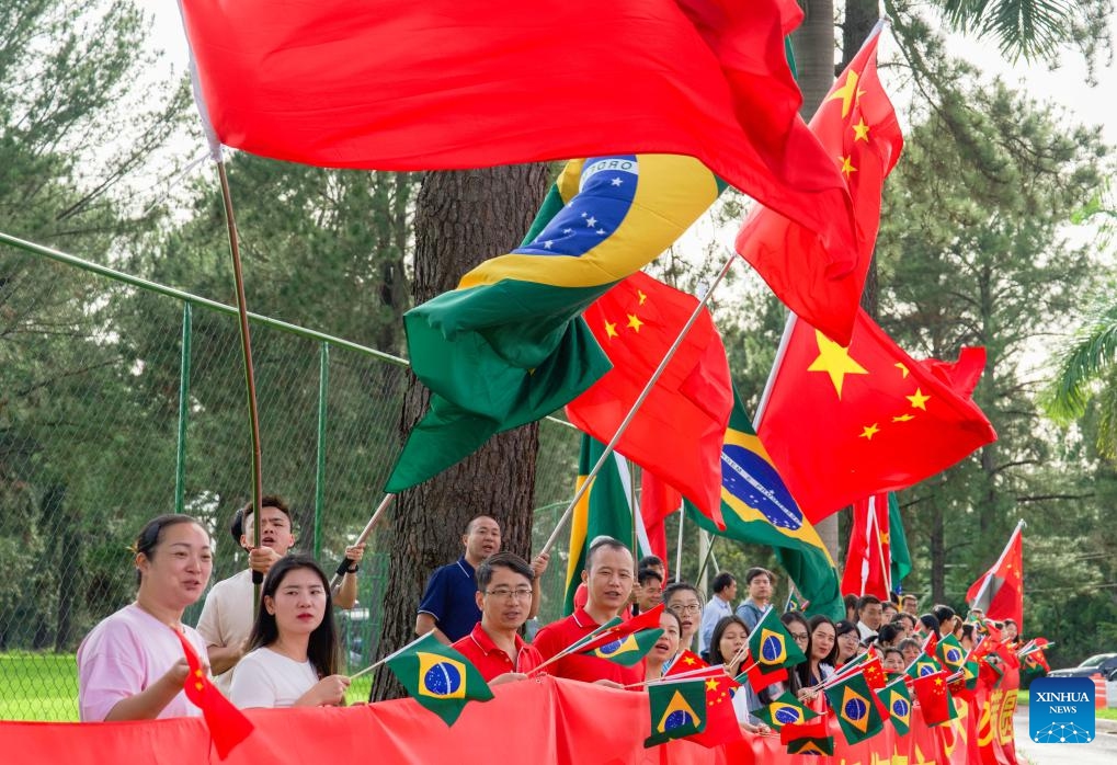 Representatives of overseas Chinese, Chinese institutions and students wave the national flags of China and Brazil on the roadside, congratulating Chinese President Xi Jinping on the complete success of his visit, while Xi's motorcade is on its way to the airport in Brasilia, Brazil, Nov. 21, 2024. Xi left Brasilia on Thursday after attending the 19th G20 Leaders' Summit and paying a state visit to Brazil. (Xinhua/Wang Tiancong)