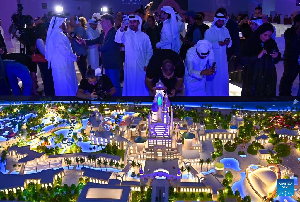 Guests take pictures of the Land of Legends Qatar model after the groundbreaking ceremony in Simaisma, Qatar on Nov. 20, 2024. The groundbreaking ceremony for Land of Legends Qatar took place on Wednesday, marking the launch of a landmark development set to become one of the largest theme parks in the Middle East and North Africa region. (Photo by Nikku/Xinhua)