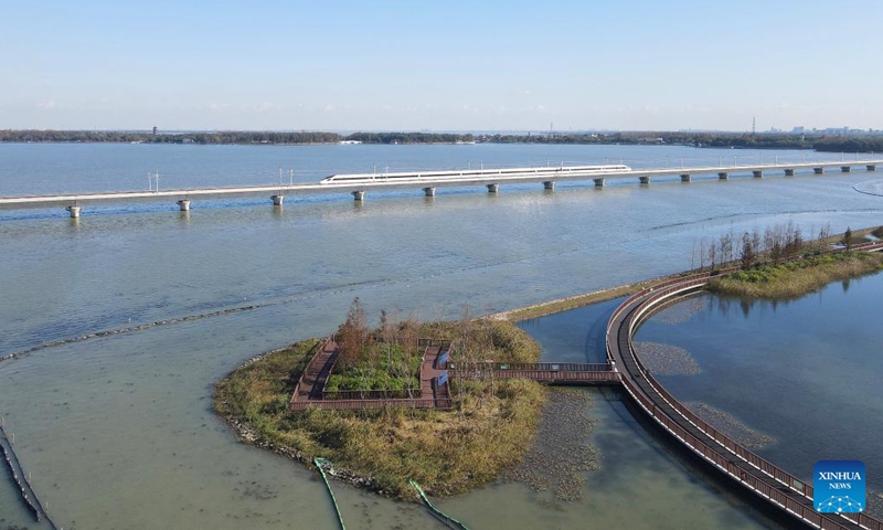 An aerial drone photo taken on Nov. 23, 2024 shows a bullet train crossing the Qingpu grand bridge along a new high-speed rail line connecting Shanghai Municipality with the provinces of Jiangsu and Zhejiang in east China. A new high-speed rail line entered trial operation on Saturday, connecting Shanghai Municipality with the provinces of Jiangsu and Zhejiang in the Yangtze River Delta in east China. (Photo: Xinhua)